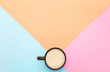 Cappuccino. Fresh coffee in a mug on geometric background with pastel colors