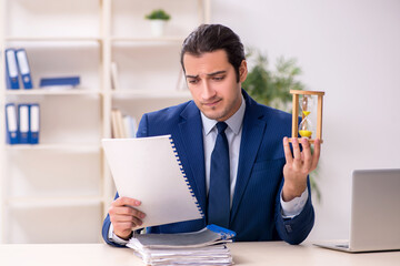 Young male employee in time management concept