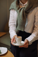 Woman in white  blouse and black trousers holding cup of coffee on the business meeting.