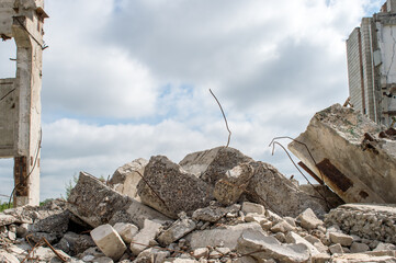 Grey concrete fragments of the Foundation against the background of a destroyed building against...