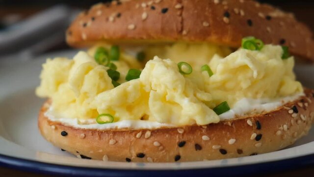 Bagel toast with scrambled egg and scallions. Closeup view breakfast sandwich with egg