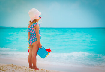 little girl play with sand on summer beach