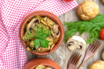 Baked pork with mushrooms and potatoes in clay pots in a stone oven. top view.