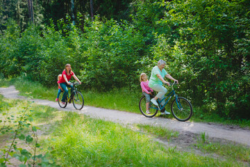 family with grandmother and kids riding bikes in nature