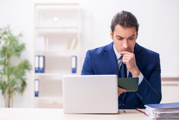 Young man checking passport in the office