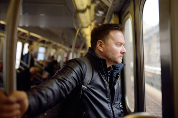 Mature man looks out the window of the car in the subway in new York.