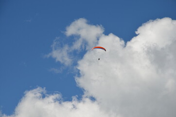 Paraglider pilot in Talloires-Montmin area near Annecy in Upper Savoy (Haute Savoie), France, blue sky background with clouds, a sunny day in summer