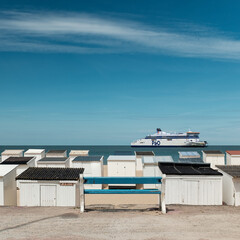 Massive ferry sailing in front of the beach of Calais.