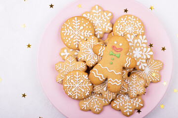 Christmas homemade gingerbread covered with powdered sugar on a pink plate