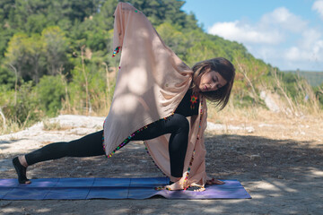 Spiritual woman practicing yoga in nature. Natural morning light shot.