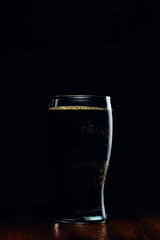 Porter beer mug with foam on a dark background