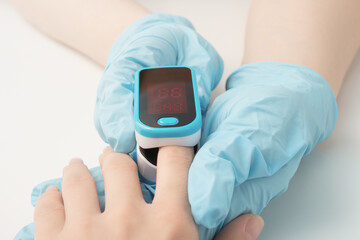 Health and medicine. A doctor in a clinic measures a patient's blood saturation with a pulse...