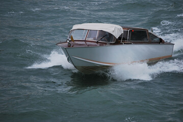 

white motorboat in the waves on a rainy day