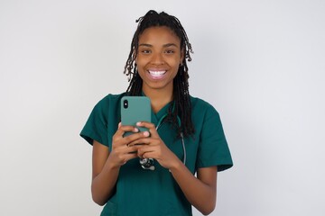 Girl turn attention at camera, distracted from smartphone smiling friendly and happily holding mobile phone as, taking selfie in mirror, showing friends new outfit, standing in dressing room of mall.