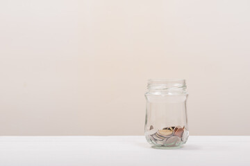 Coin in Jar or glass bottle with soft white background. Saving money, Saving concept