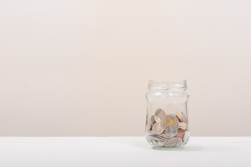 Coin in Jar or glass bottle with soft white background. Saving money, Saving concept