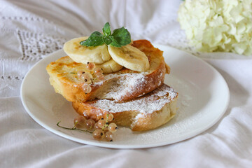 Fried toast with bananas in bed and a glass of wine