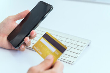 A man using a smart phone and holding a panoramic banner of a credit card Young businessmen or entrepreneurs who work at the office Online shopping