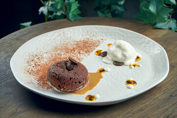 Dessert - chocolate fondant with white ice cream and chia in a white plate