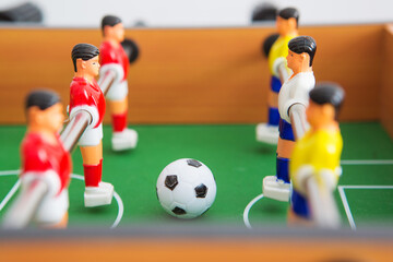 Table football game with yellow and red players and white goalkeeper.