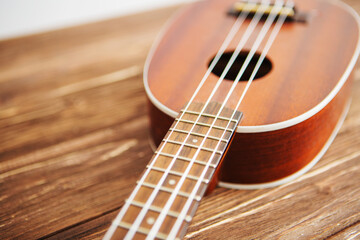Photo depicts musical instrument ukulele guitar on a wooden