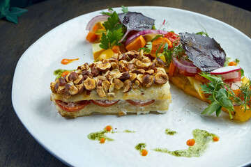 Baked pike perch fillet with peanuts and vegetable salad garnish in a white plate. Seafood