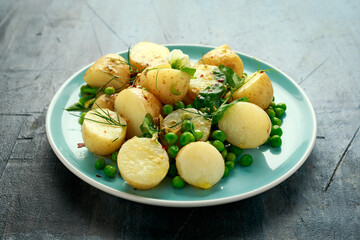 Warm vegetarian new baby potato salad with petit pois peas, Dijon mustard and capers dressing, served with fresh dill