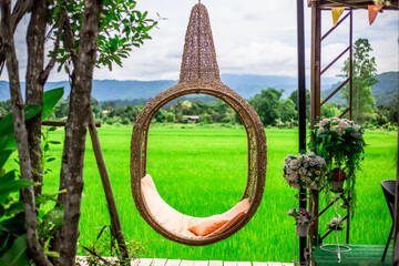 background of the chair is made of wood and has a view of the surrounding green fields, and the wind blows through the cool blurs while traveling.