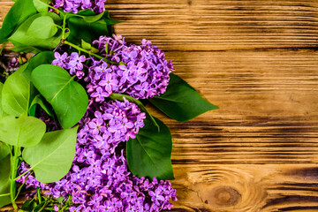 Flowers of lilac plant on wooden background. Top view