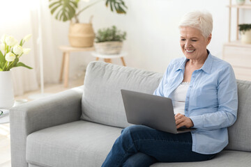 Business After Retirement. Smiling Senior Woman Working On Laptop Computer At Home