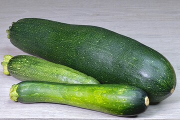 a group of cut fresh zucchini in the skin on a light table