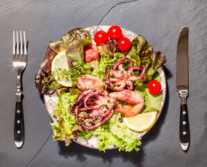 Octopus on blue plate with salad and lemon