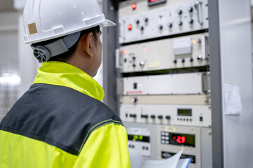 Electrical engineer woman checking voltage at the Power Distribution Cabinet in the control room,preventive maintenance Yearly,Thailand Electrician working at company