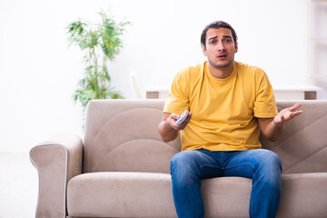 Fototapeta premium Young man watching tv at home