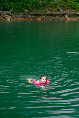 Portrait of cute little Asian girl swimming, happy child having fun in water, beach resort, summer vacation and holidays concept.