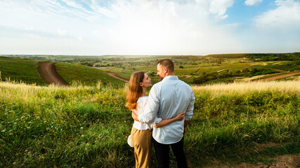 Young couple enjoying landscape outdoors, back view
