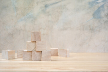 Wooden toy cubes on wooden table ang grey background