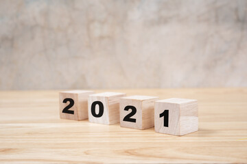 2021 happy new year on wood block on wooden table ang grey background. new year concept.
