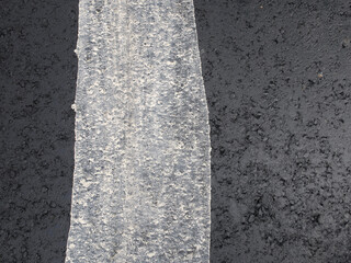 white stripe of paint on a black asphalt road