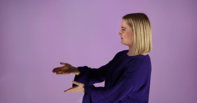Eine junge Frau mit kurzen blonden Haaren im blauen Pulli h&auml;lt eine Pr&auml;sentation