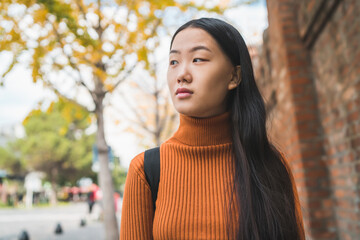 Portrait of young Asian woman in the street.