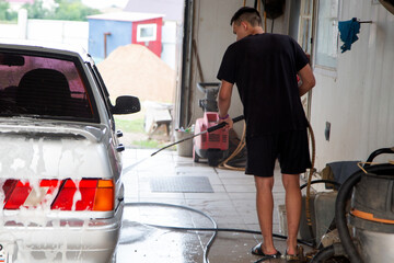 male car washer covers the car with foam