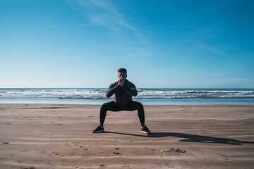 Athletic man doing exercise at the beach.