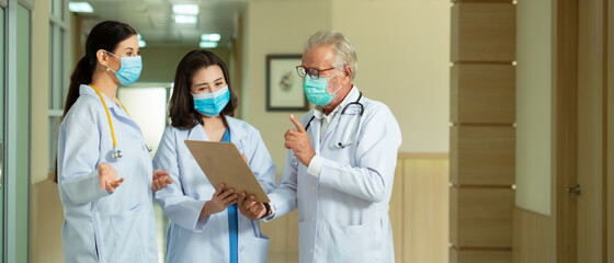 Professional  doctors  wearing mask consult while walking  at hospital