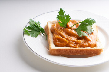 healthy toast with zucchini caviar. Russian traditional sandwich served in a plate with herbs on a white table