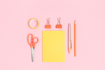 Set of yellow stationery on a pink pastel background. School equipment layout.
