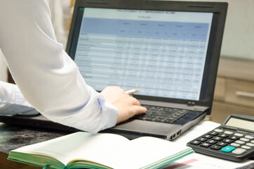  the girl sits at the computer and makes a financial report. work at home. learning at home. home business.