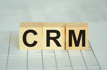 text CRM written on cubes and financial statements. financing
