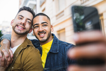 Gay couple taking a selfie in the street.