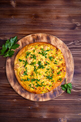 homemade pizza with meat and cheese and vegetables on a wooden table. Copy space Top view